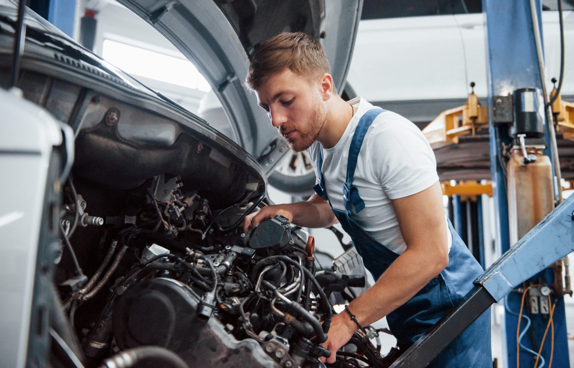 mechanic working on removing engine and transmission